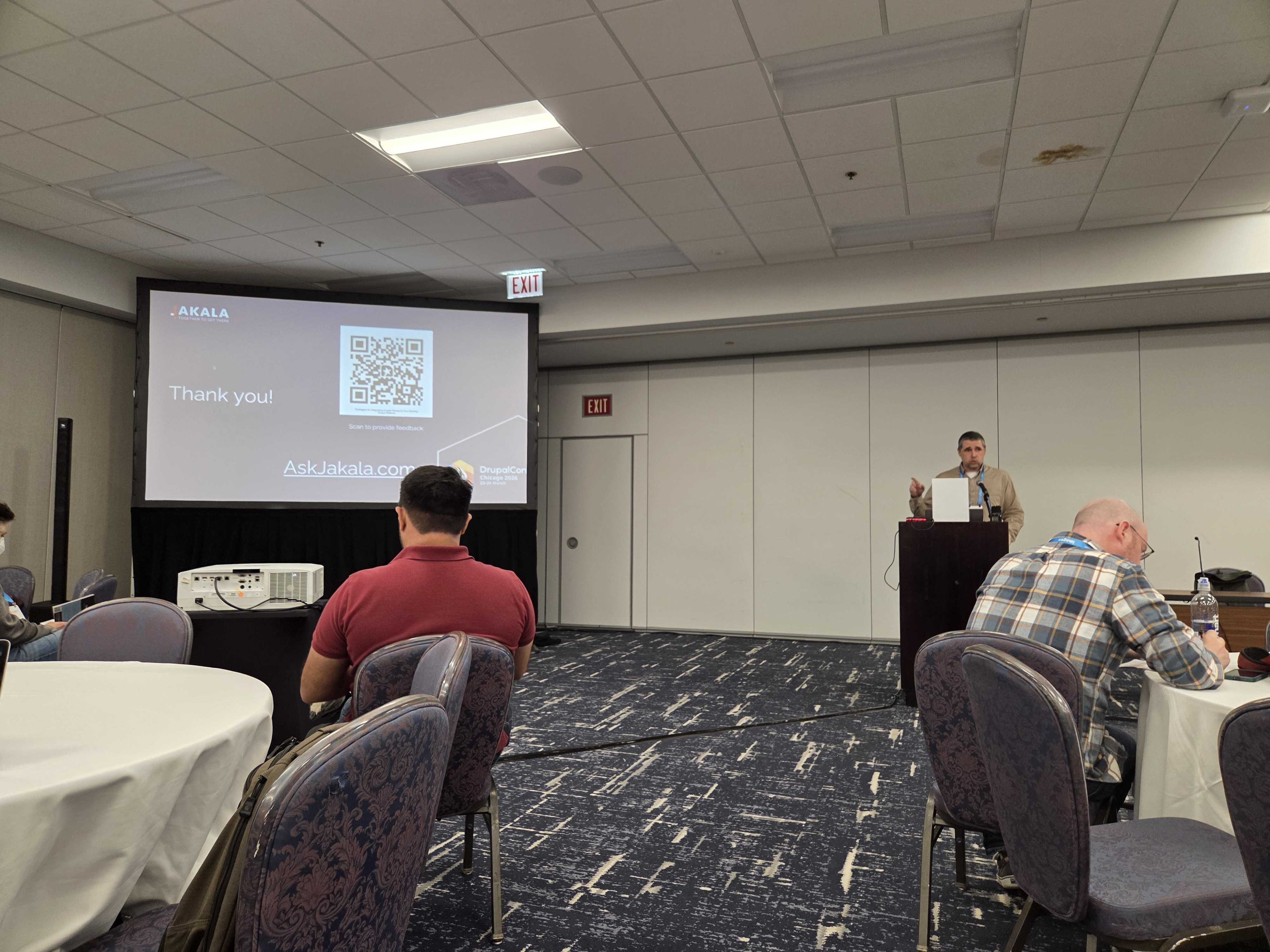 Man stands on platform to present next to a screen