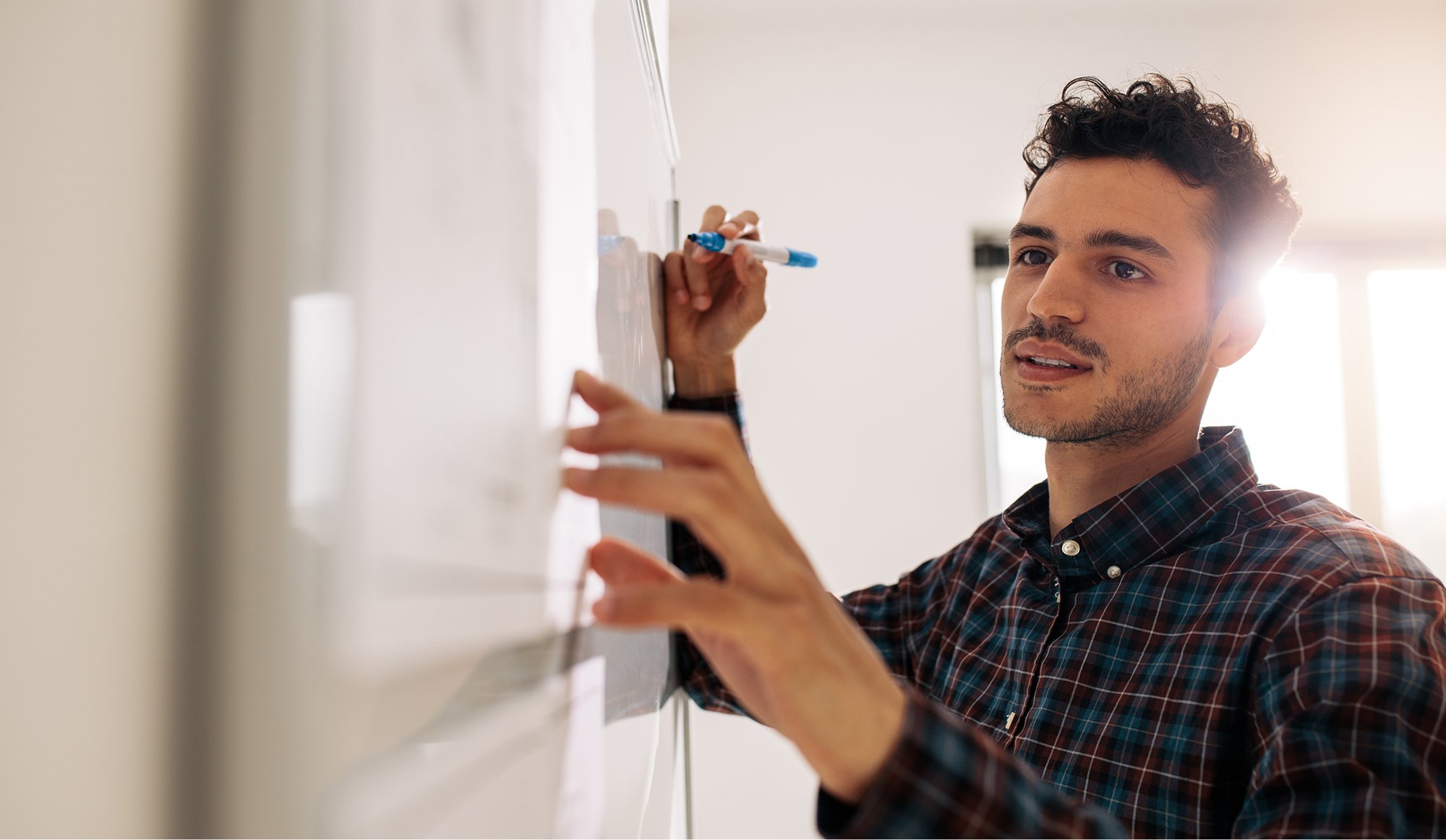 Jakala Solution Designer working on whiteboard in client workshop